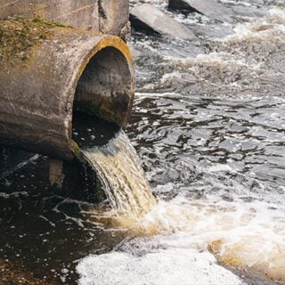 肮脏的，受污染的液体从管道中泄漏到水源中。